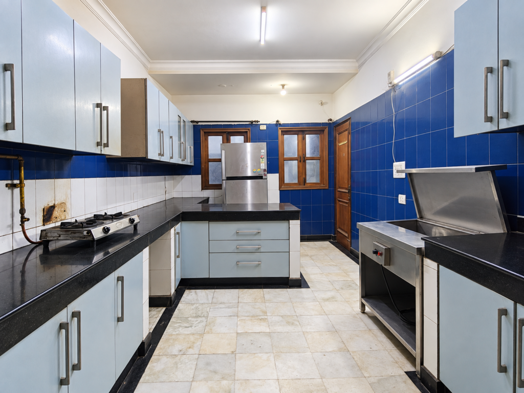 Shared kitchen with cupboards and cooking facilities at GableStay C-23 in Sector 33, Noida