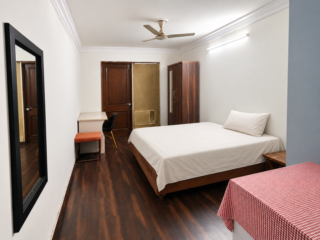 Furnished room with a white bed and wooden flooring at GableStay C-23 in Sector 33, Noida