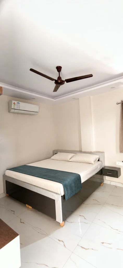 Furnished co-living room with bed and study area at GableStay