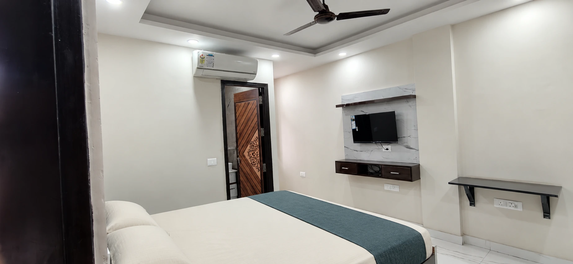 GableStay private room with television and styled ivory bedding