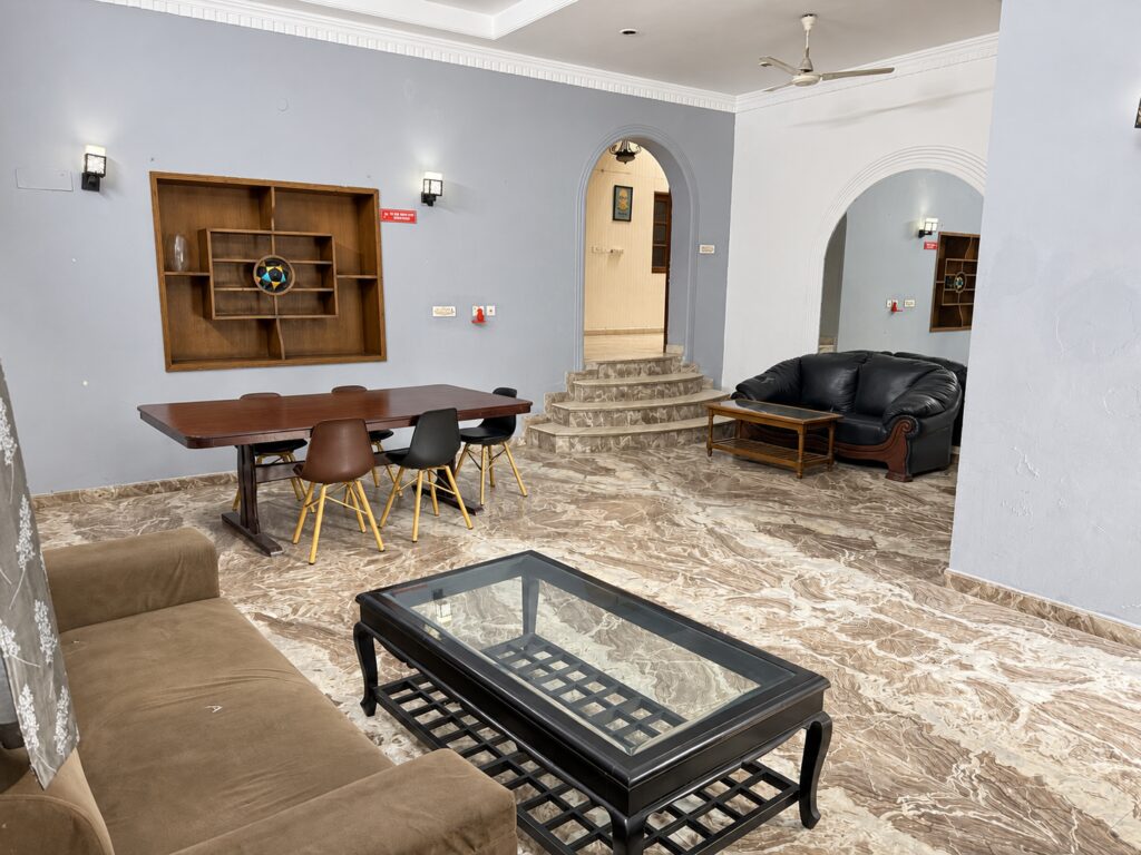 Sofa seating, dining table and arched doorway at GableStay girls’ PG in Sector 33, Noida