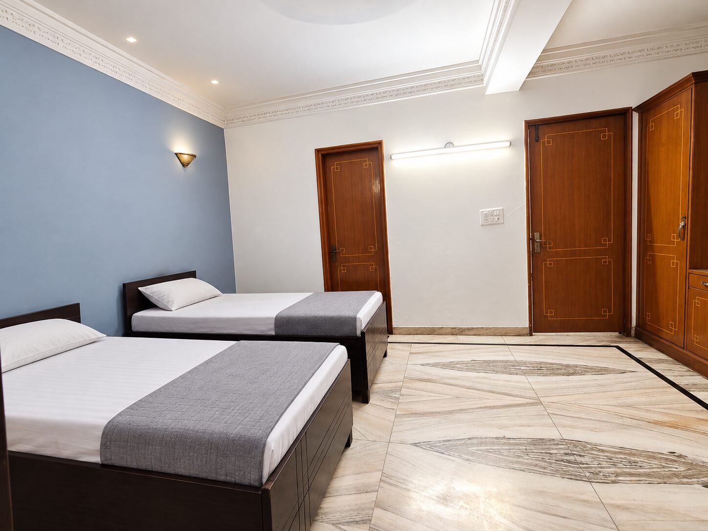 Girls’ PG double-sharing room with grey bed runners